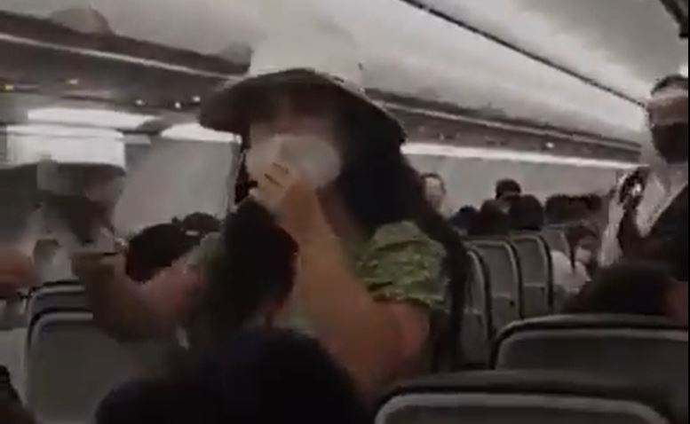 mujer en avion sin cubrebocas