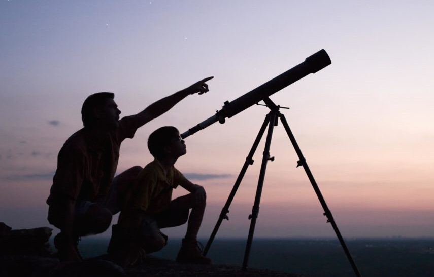 Father & sone looking trough telescope